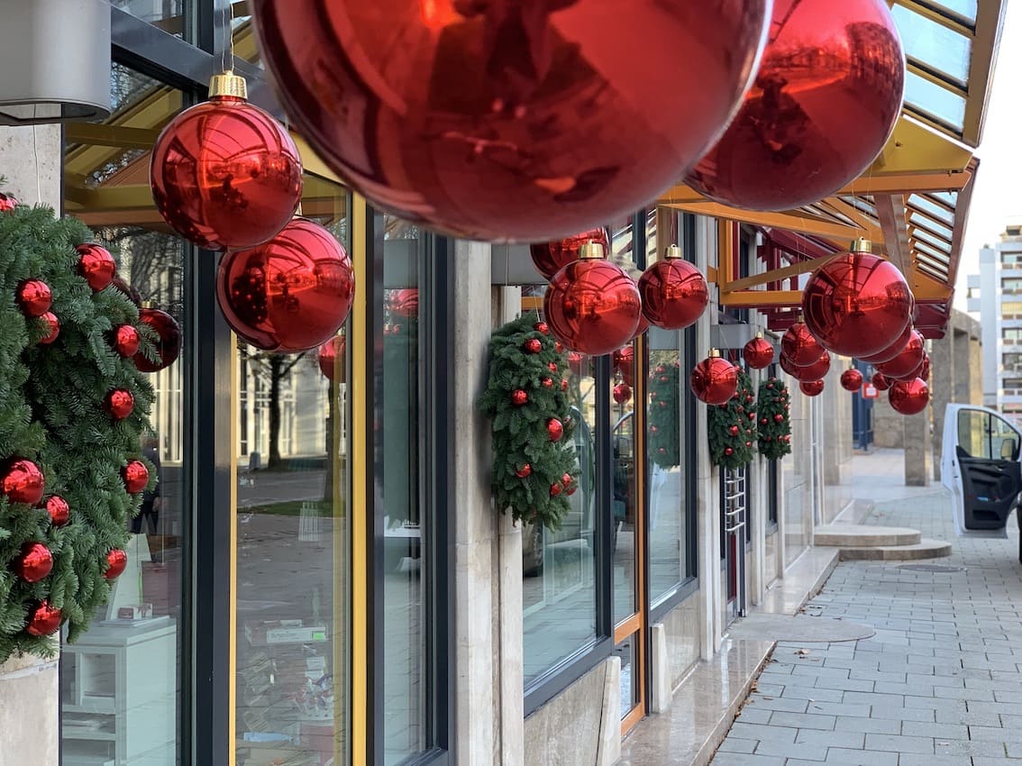 Rote Weihnachtskugeln vor Geschäft