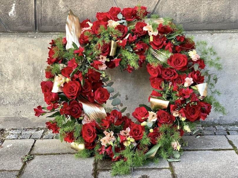 Trauerkränze mit roten Blumen München