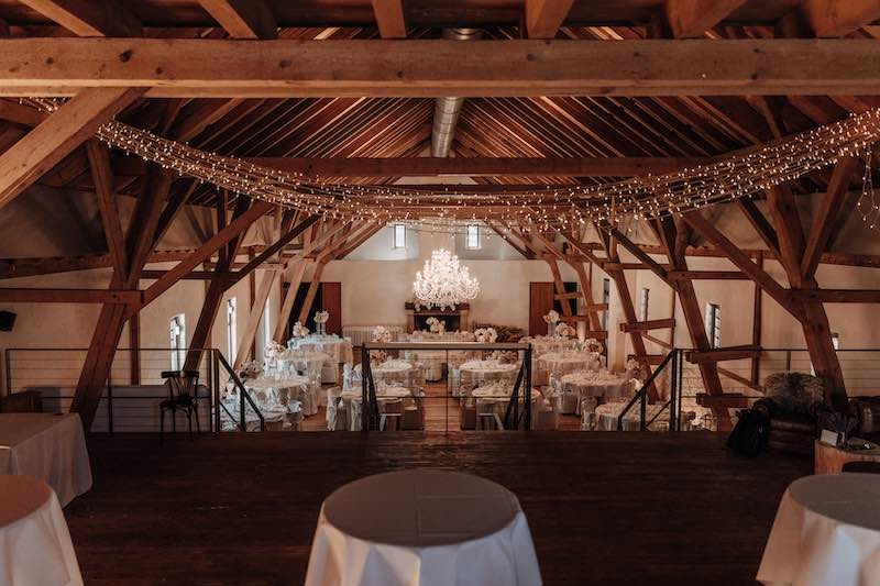 Dekoration Hochzeitssaal mit Holz und pastellfarbenen Blumen